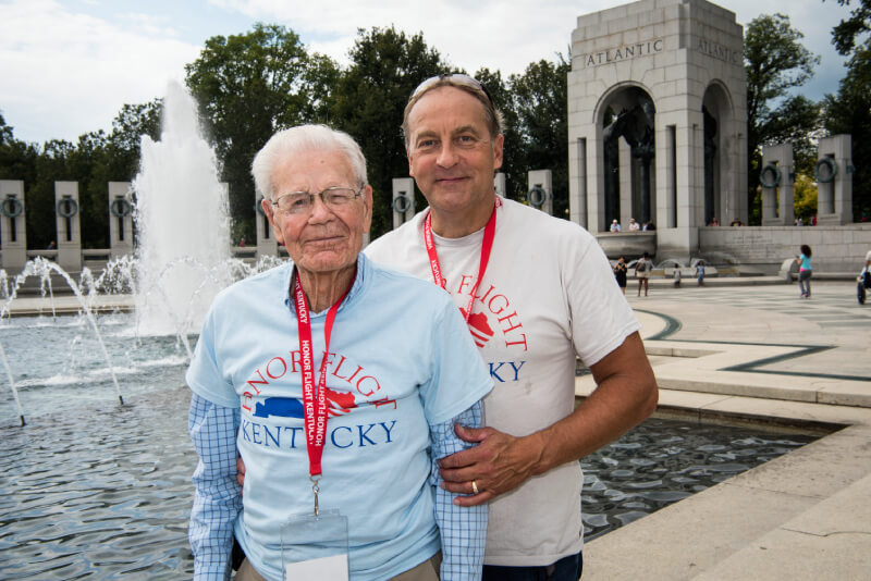 Guardian and Veteran standing in front of a memorial